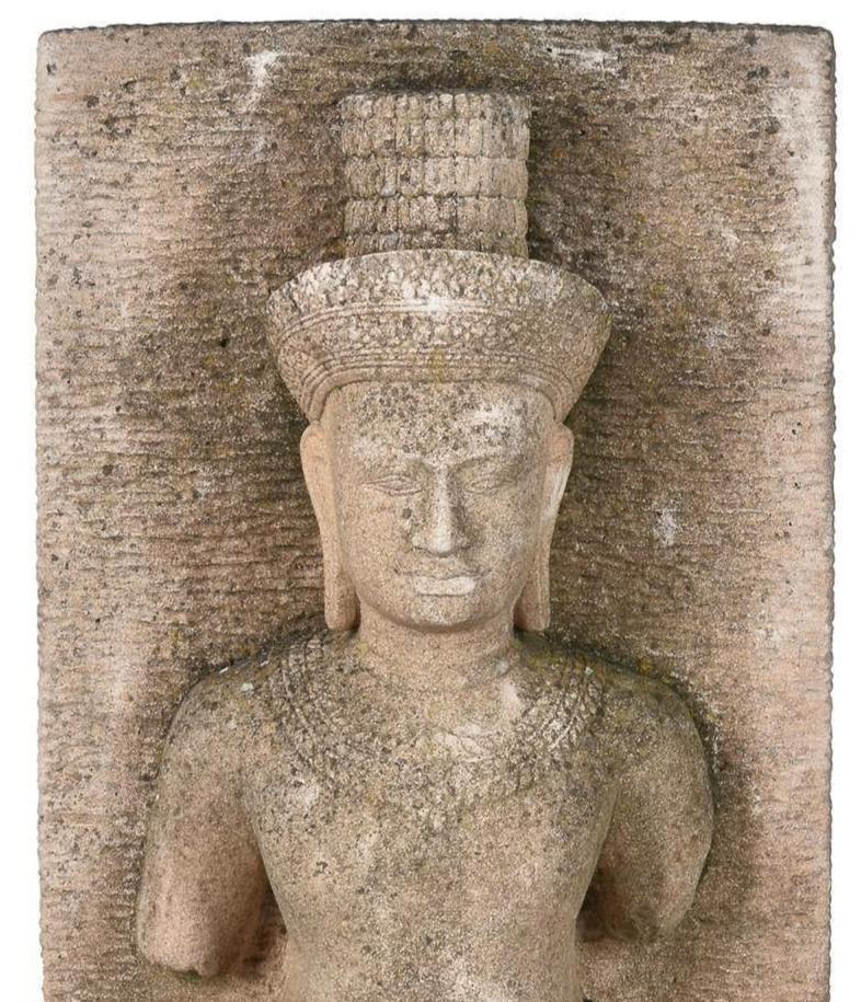 A Khmer style sandstone relief panel depicting a male deity